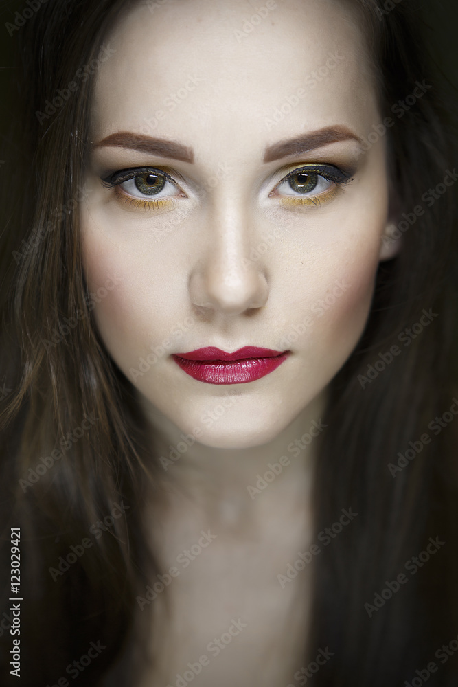 Portrait of a beautiful young girl on a dark green background