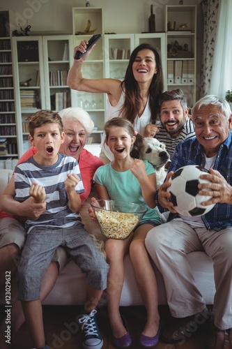 Happy family watching soccer match on televisio