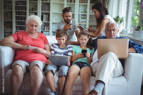 Family using laptop, mobile phone and digital t