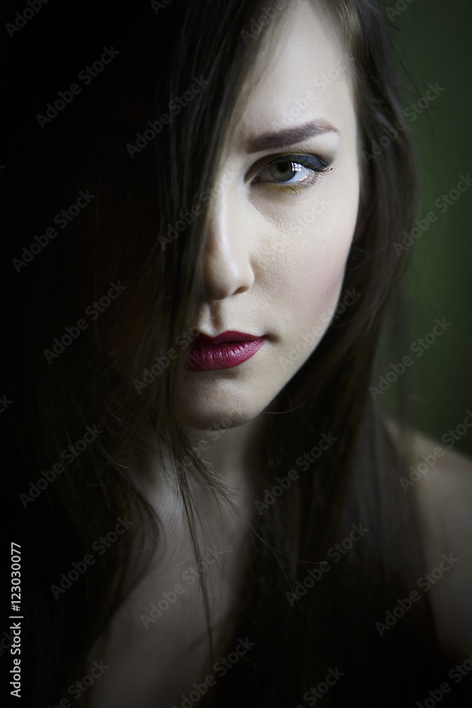Portrait of a beautiful young girl on a dark background