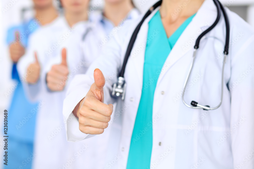 Group of doctors showing OK or approval sign with thumb up. High level and quality medical service, best treatment and patient care concept Group of doctors showing OK or approval sign with thumb up. High level and quality medical service, best treatment and patient care concept