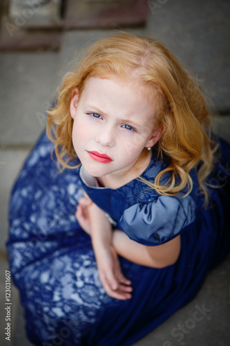 Portrait of beautiful little girl in the Park on the stairs