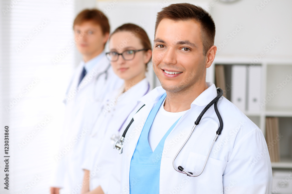 Cheerful smiling male doctor with medical staff at the hospital Cheerful smiling male doctor with medical staff at the hospital