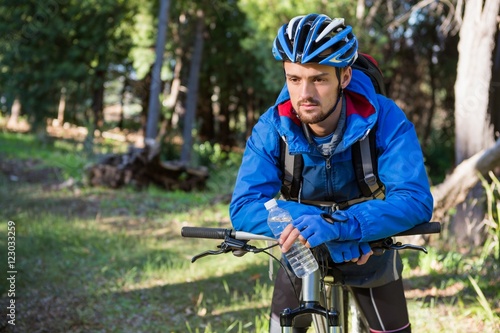 Male mountain biker standing with bicycle