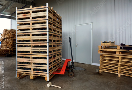 Manual forklift pallet with a stack of wooden crates in a wareho photo