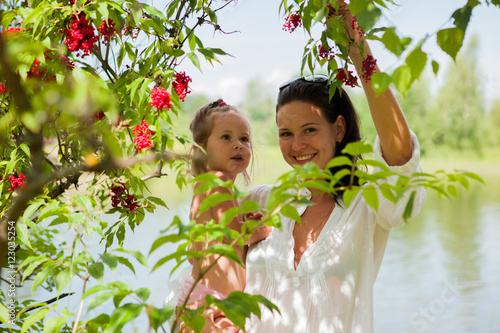 Portrait of mother and daughter outdoors forest river grass