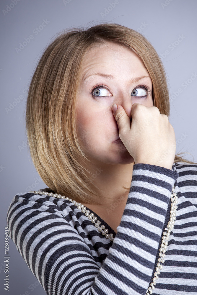 Portrait of a beautiful girl in a grey striped t-shirt with emotions in the Studio