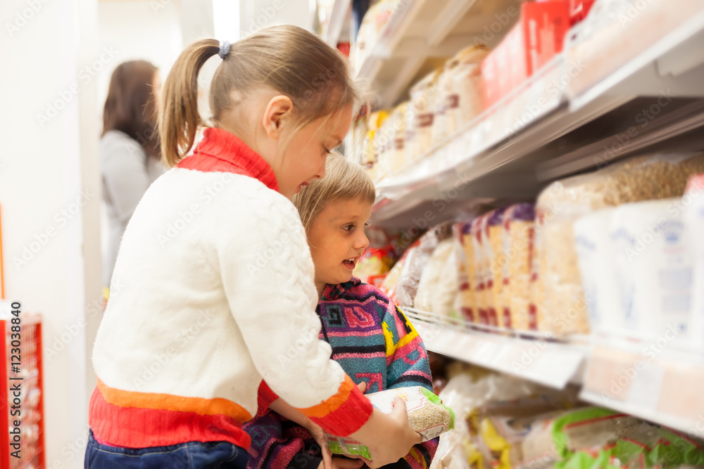 children in store at shelves with products. children in store at shelves with products.