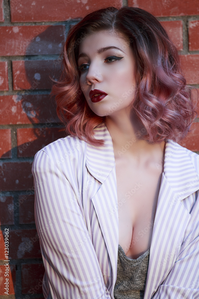 Portrait of a beautiful young girl in costume with the tattoo on the background of red brick wall Portrait of a beautiful young girl in costume with the tattoo on the background of red brick wall