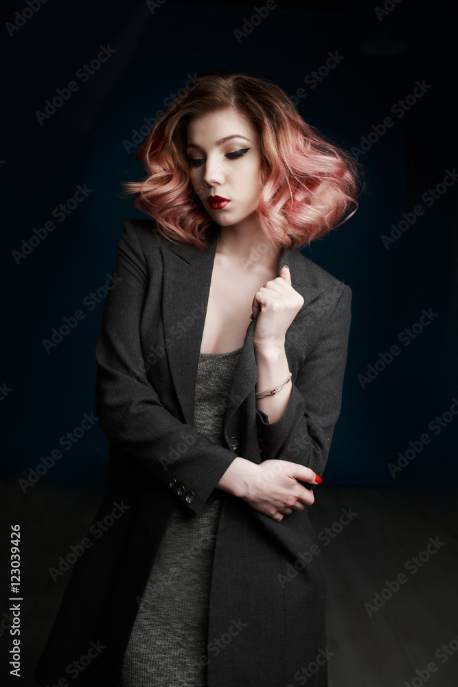 Portrait of a beautiful girl in a black suit on a black background