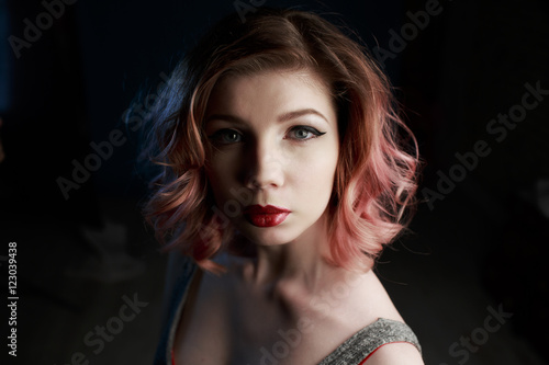 Portrait of a beautiful girl in a black suit on a black background