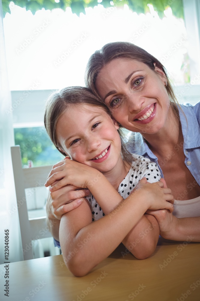 Fototapeta premium Happy mother and daughter embracing at home