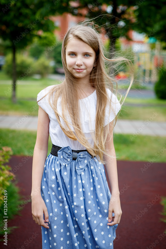 Naklejka premium Portrait of a beautiful young girl in the Park skirt blouse nature fashion style