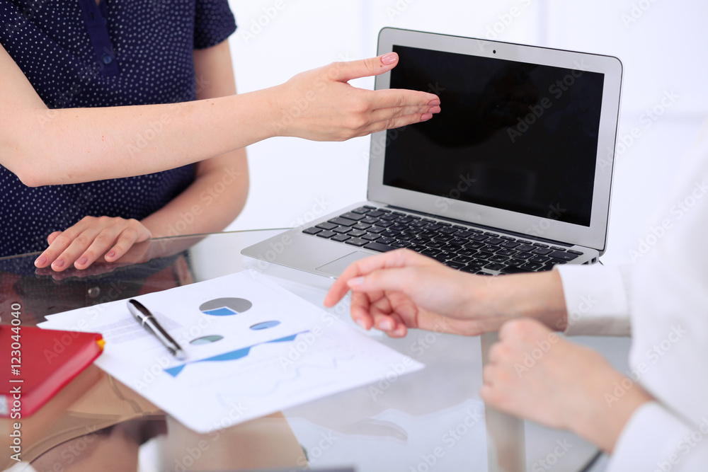 Group of business people at meeting discussing financial results. Women pointing into laptop computer monitor Group of business people at meeting discussing financial results. Women pointing into laptop computer monitor
