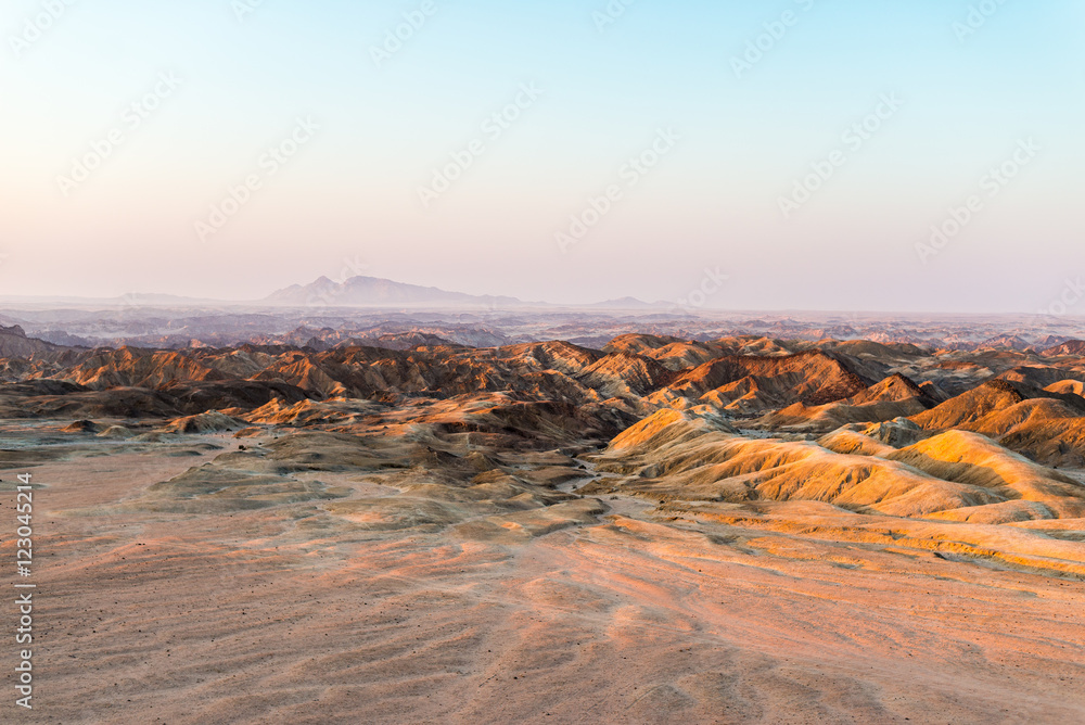 Sunset light over barren valleys and canyons, known as 