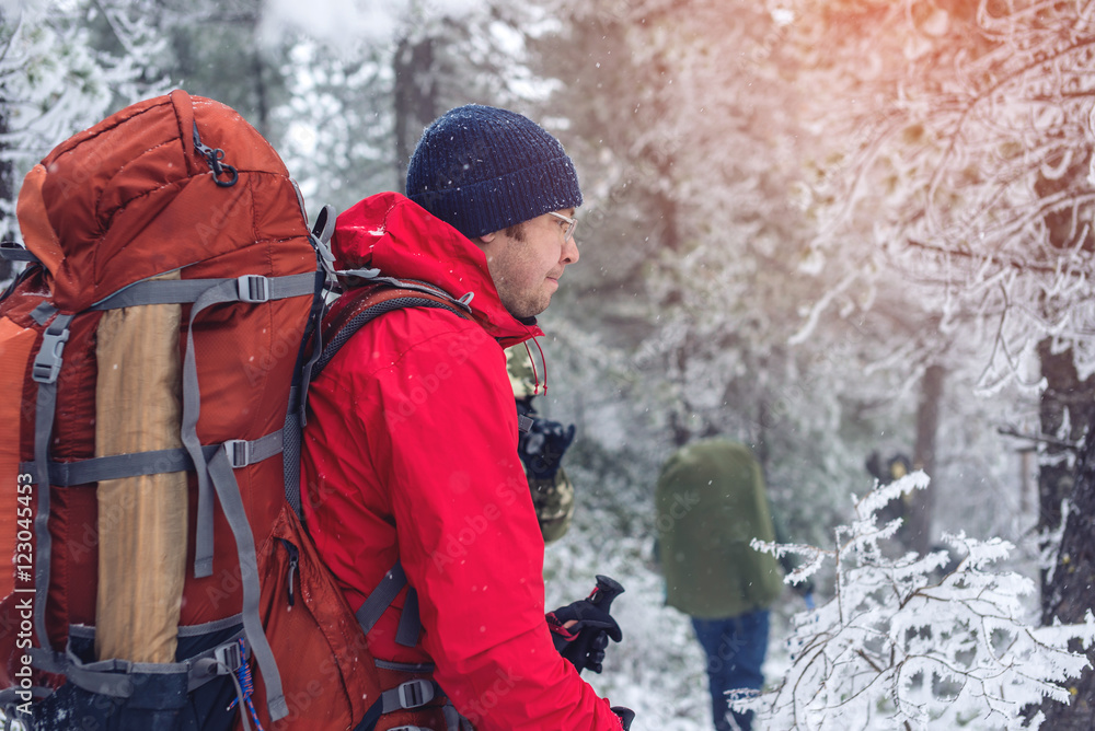 Winter landscape. Tourist in red jacket goes on the hill Winter landscape. Tourist in red jacket goes on the hill
