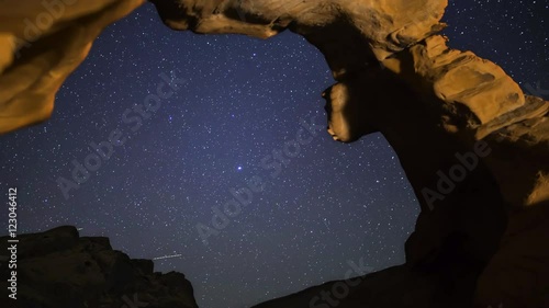 Astrophotography time lapse with pan left motion of starry sky over Arch Rock in Valley of Fire State Park, Nevada photo