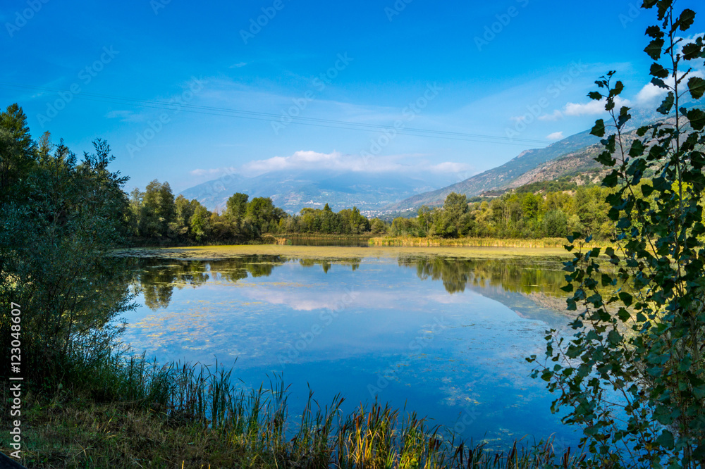 Fototapeta premium mountains, sky and clouds reflected in the lake
