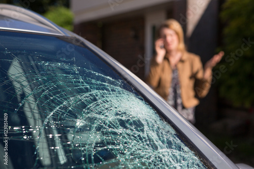 Woman Phoning For Help After Car Windshield Has Broken photo