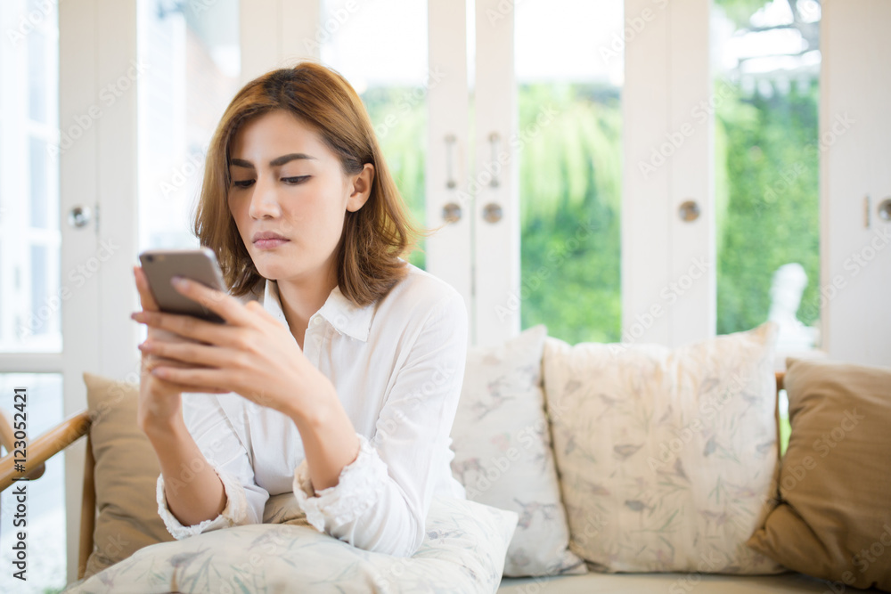 beautiful asia woman using smart-phone in living room beautiful asia woman using smart-phone in living room