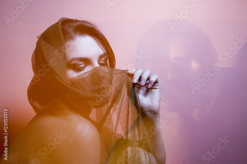 Portrait of a woman with transparent Head Cover in rays of light