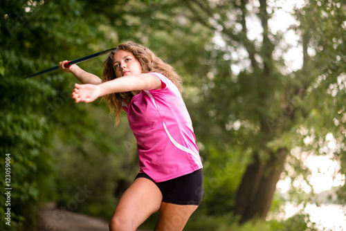 Young athlete throwing a javelin in nature