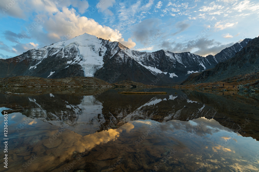 Reflection of clouds on sunset in the mountainous lake. Valley of seven lakes, Gorny Altai, Russia.