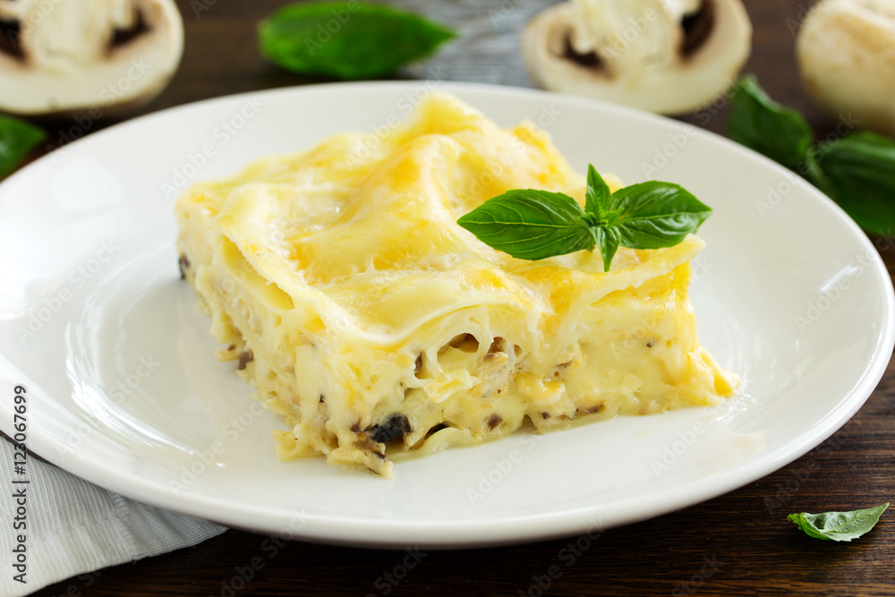 A piece of lasagna with chicken and mushrooms. A piece of lasagna with chicken and mushrooms.