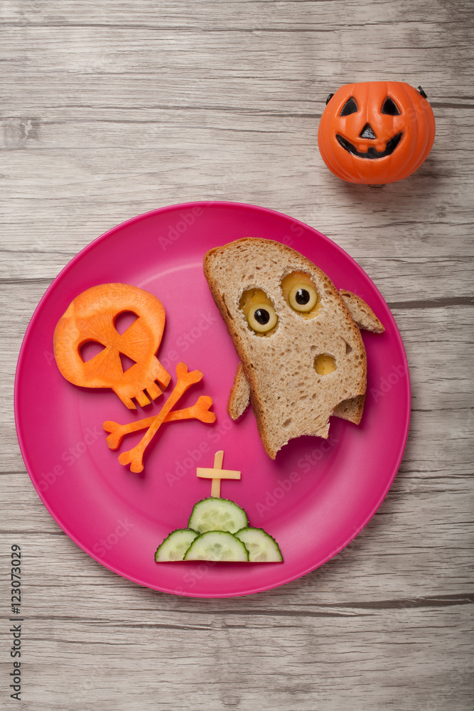 Halloween ghost and skull made of bread and carrot on board Halloween ghost and skull made of bread and carrot on board