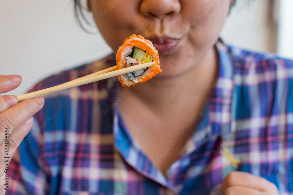 Wunschmotiv: Asia woman holding chopsticks with a california roll #123076851