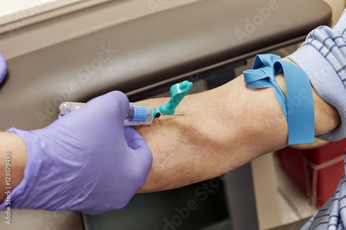 Technician drawing Blood from a Mans Arm