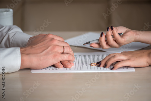 Wife and husband signing divorce documents, woman returning wedding ring