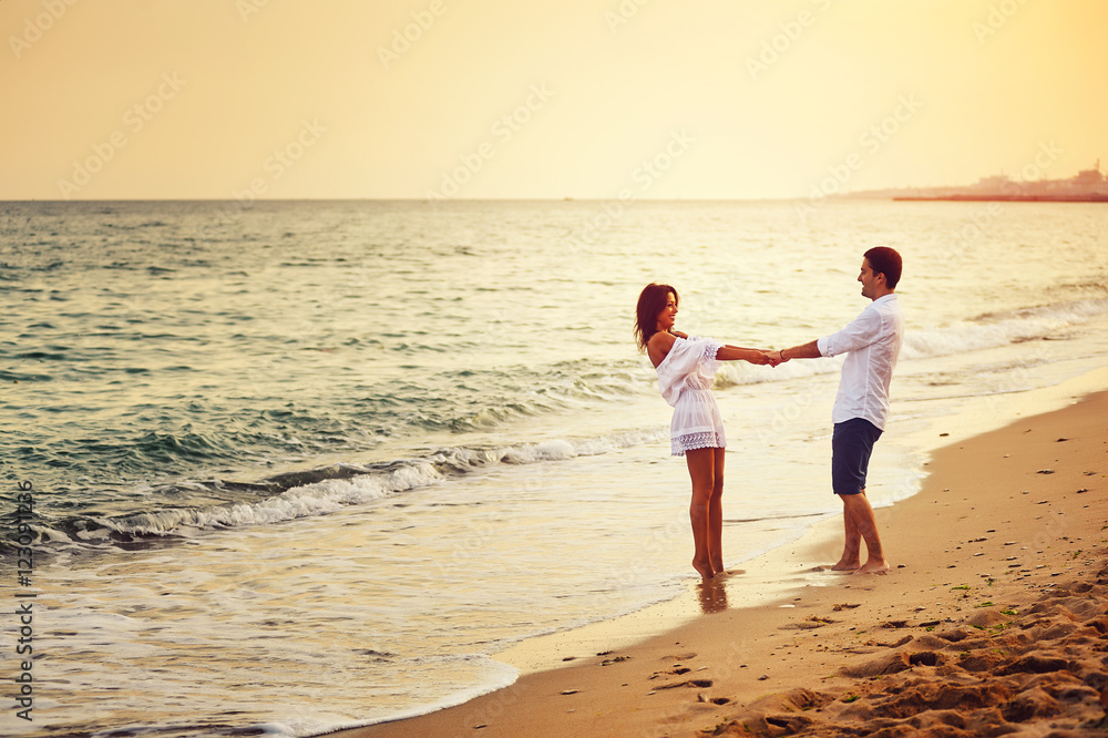 Beautiful romantic couple on the sea shore during sunset