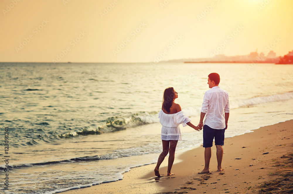 Beautiful romantic couple on the sea shore during sunset