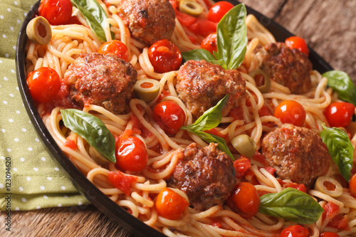 Spicy pasta with meatballs, olives, basil and tomato sauce closeup. horizontal
