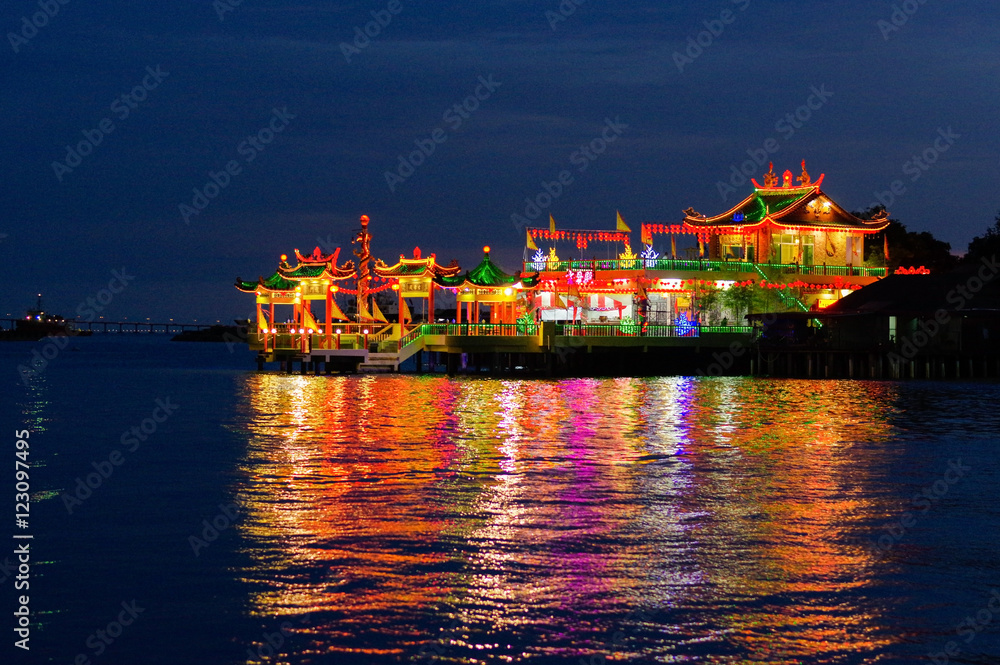 Naklejka premium GEORGETOWN, MALAYSIA - NOVEMBER 18,2016: nightview of Hean Boo Thean Kuanyin Chinese Buddhist temple in Clan Jetties by night. Built on stilts over the harbor George Town