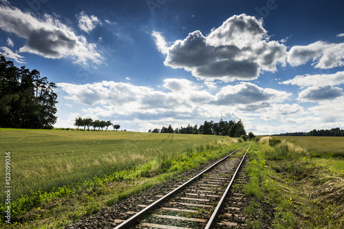 Empty Rail Track with Blue Sky and Green Field