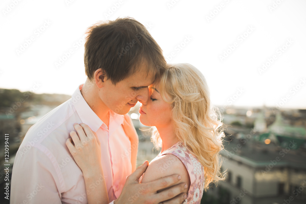Close up portrait of happy smiling couple in love posing on roof with big balls. Landscape city Close up portrait of happy smiling couple in love posing on roof with big balls. Landscape city