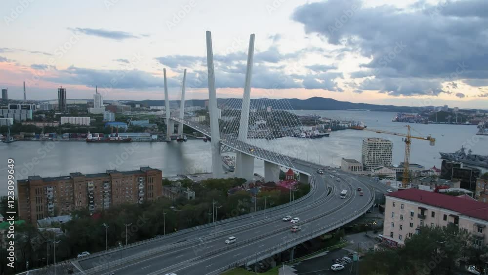 Panoramic views of sea harbour Vladivostok. New modern able-stayed bridge over Golden horn Bay. Panorama from top of city at sunset. Change time from evening to night. Life of port city time-lapse . Panoramic views of sea harbour Vladivostok. New modern able-stayed bridge over Golden horn Bay. Panorama from top of city at sunset. Change time from evening to night. Life of port city time-lapse .