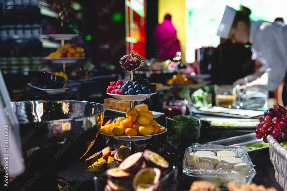 Tasty fruits lie on silver serving dishes on the buffet covered Tasty fruits lie on silver serving dishes on the buffet covered
