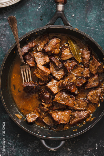 Braised beef stew in a pot. Stewed meat casserole. Top view.