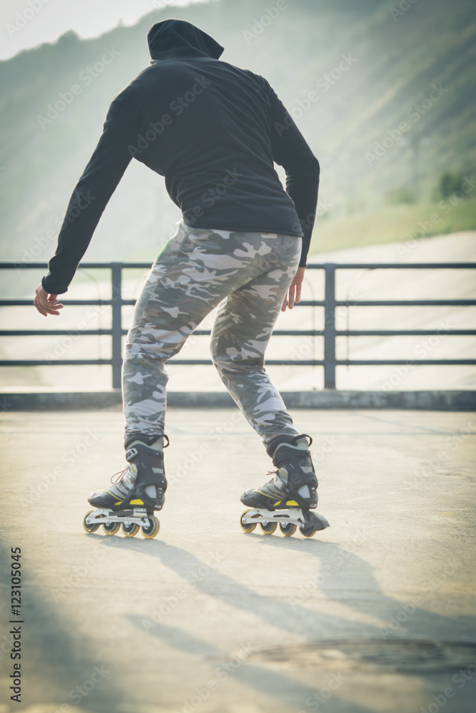young man with inline skates ride in summer park seafront outdoor rollerskater young man with inline skates ride in summer park seafront outdoor rollerskater