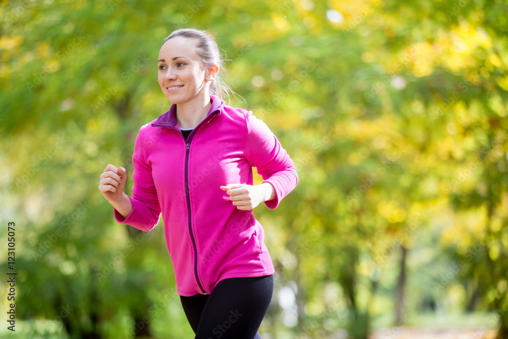 Portrait of an attractive smiling woman jogging in the fall time. Concept photo Portrait of an attractive smiling woman jogging in the fall time. Concept photo