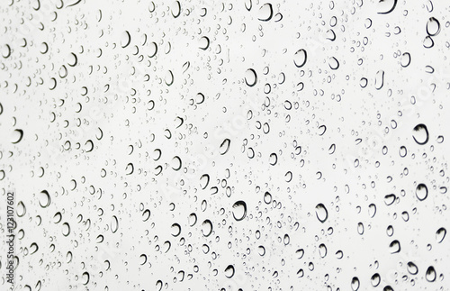 Rain water drops on car window glass during cloudy raining day.