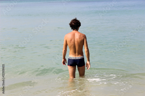 man walking through sea and splashing water. Vacations on seashore © evolutionnow