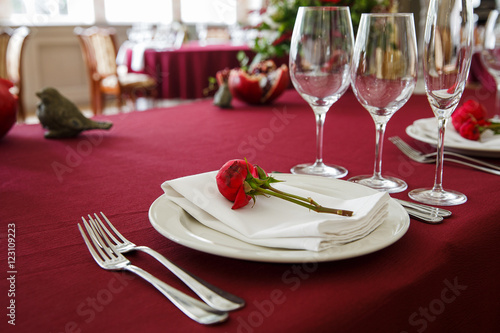 Festive table serving with a rose bud on a white plate
