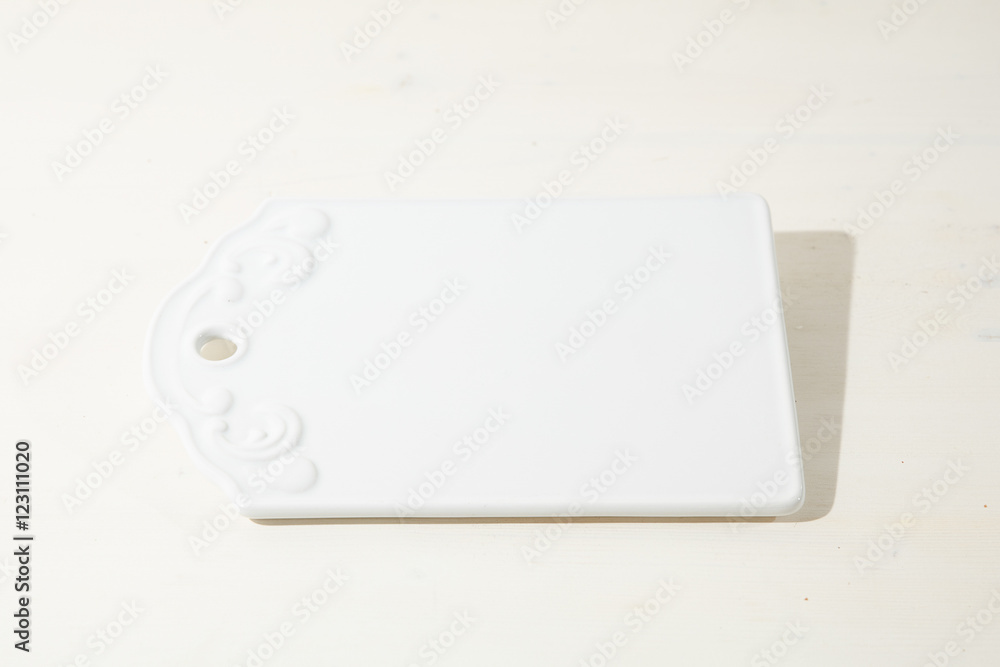 Square white serving dish with flower design stands on the white Square white serving dish with flower design stands on the white
