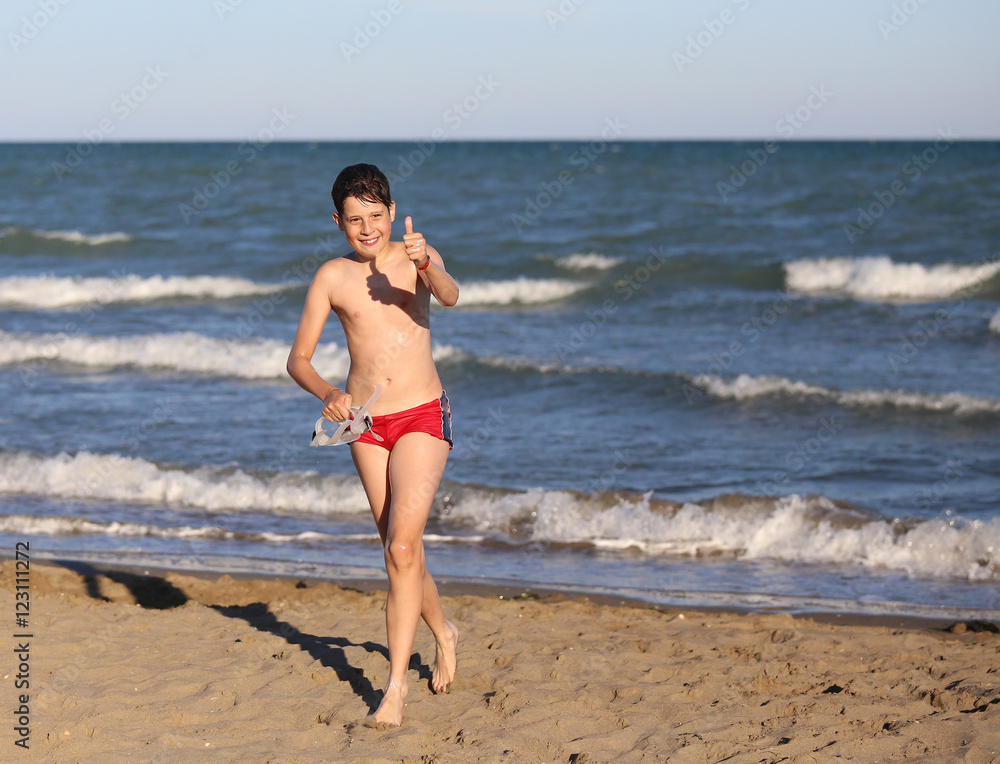 carefree boy runs by lifting the thumb of the hand as a sign of carefree boy runs by lifting the thumb of the hand as a sign of