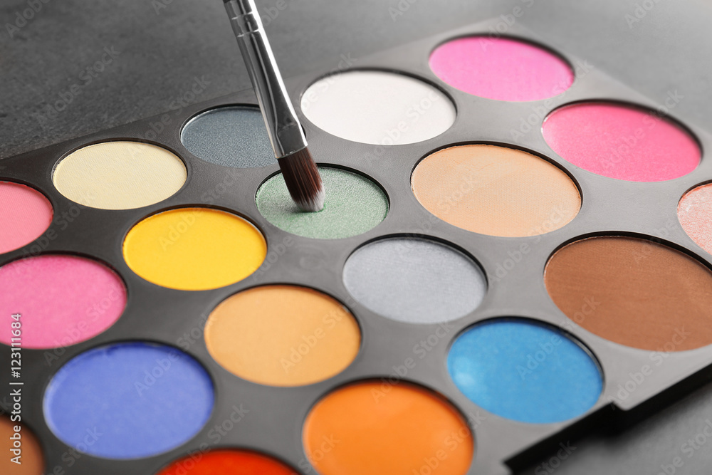 Naklejka premium Colorful eye shadow palette with brush, closeup