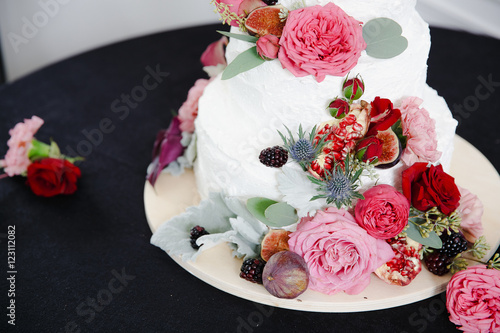 Berries and peonies beautify a wedding cake © nastasenko